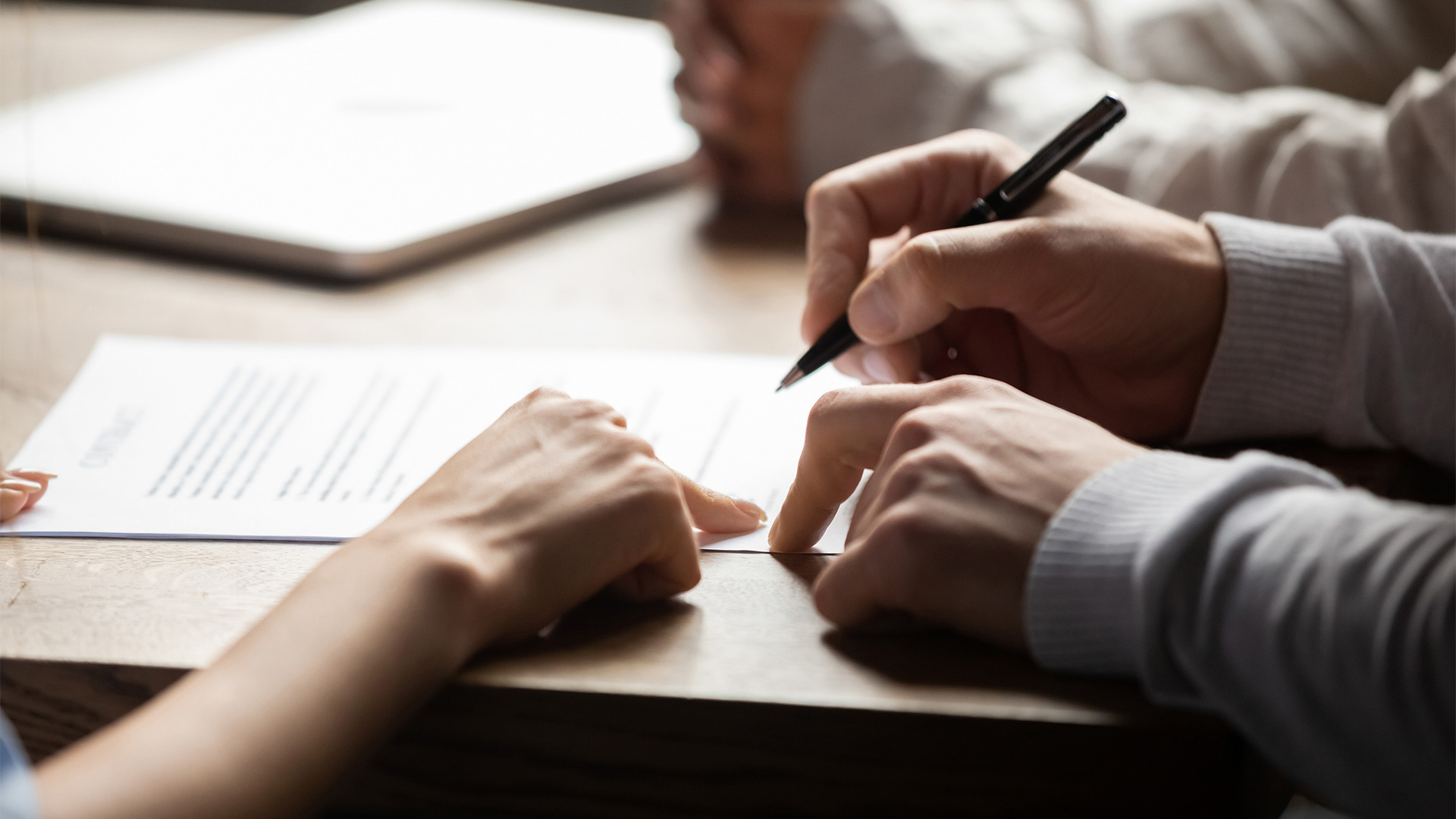 client hands close up signing insurance contract houston tx