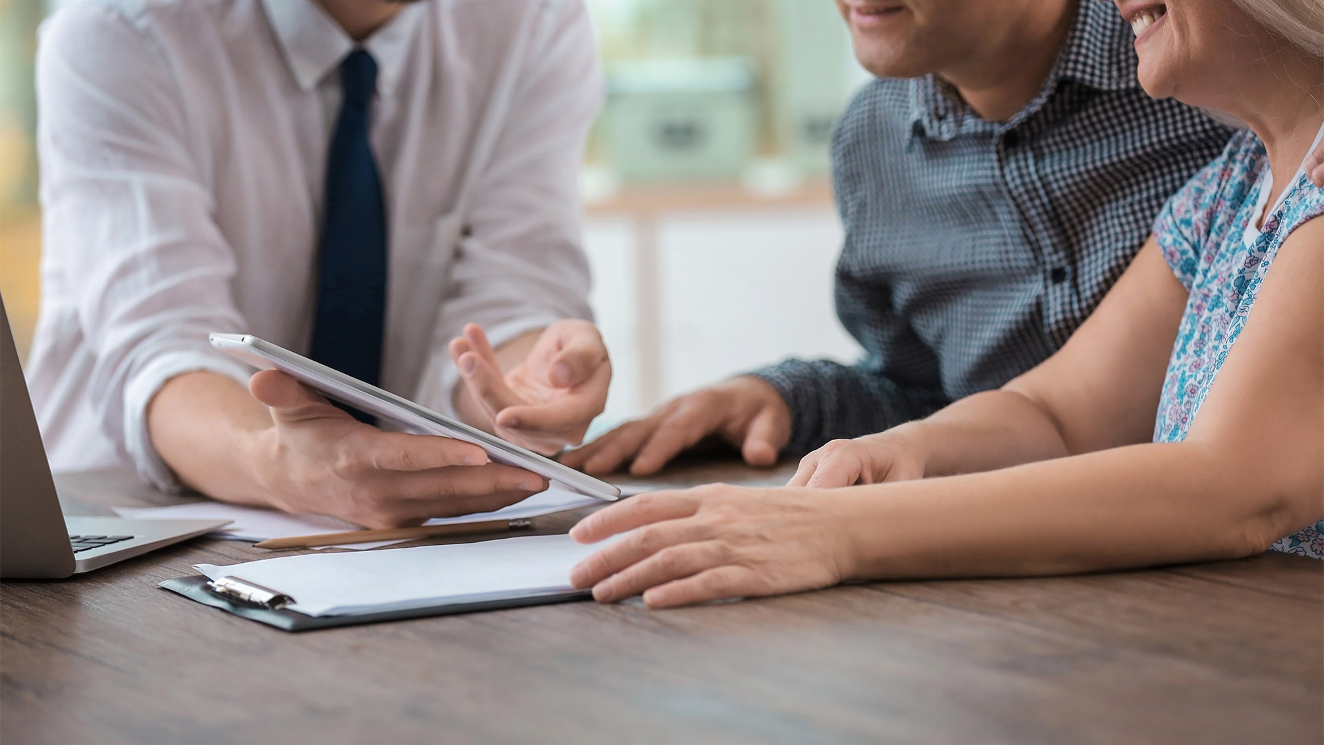 insurance agent explaining policies to married couple on an ipad kingwood tx